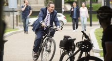 Kevin Sheehy riding bike in suit