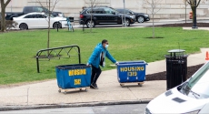 Student in mask moving out with housing bins