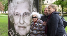 Holocaust survivor in front of her portrait
