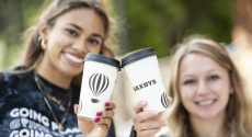 Two students holding Saxbys cups