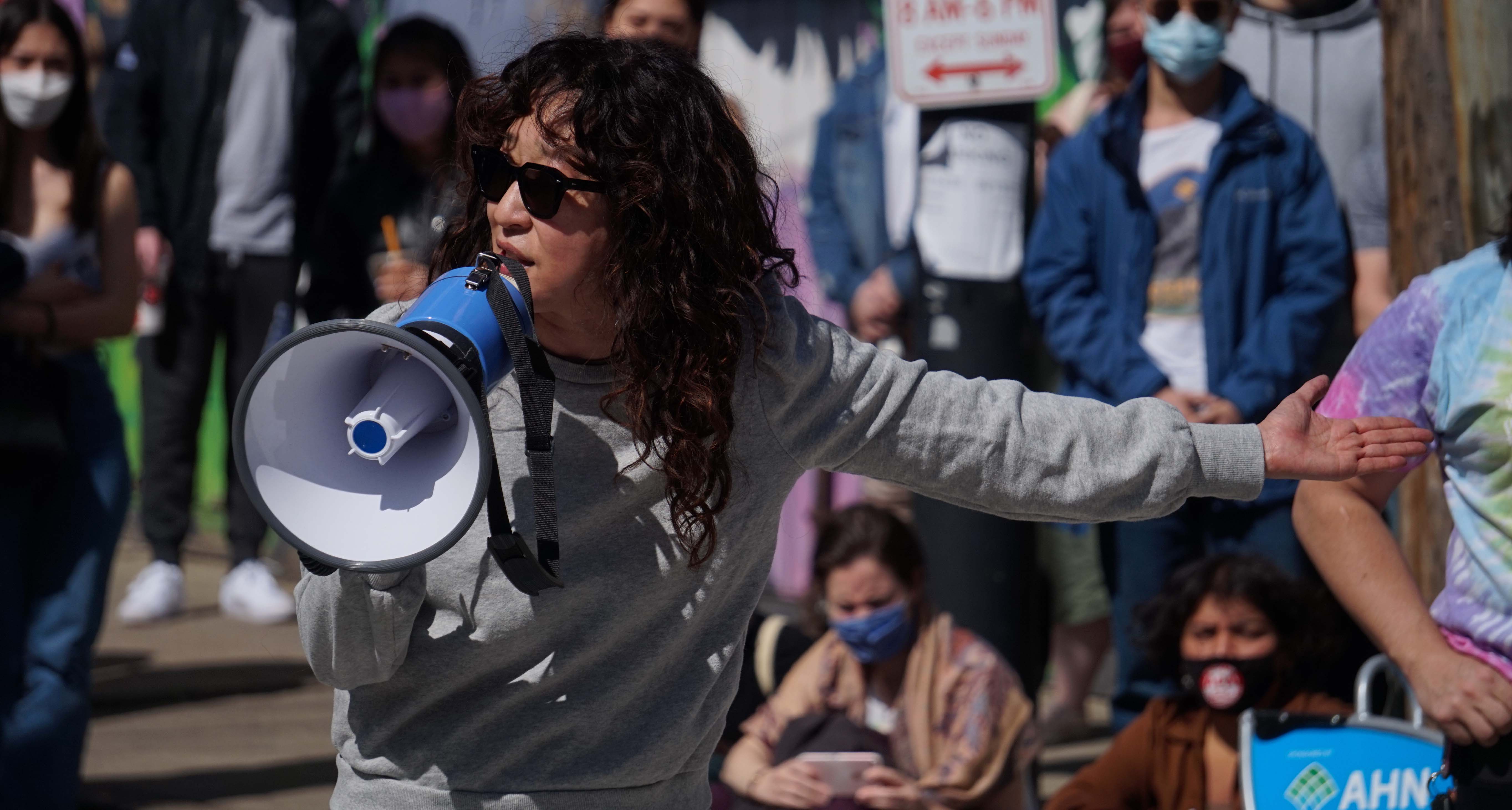 Woman addressing crowd with bullhorn