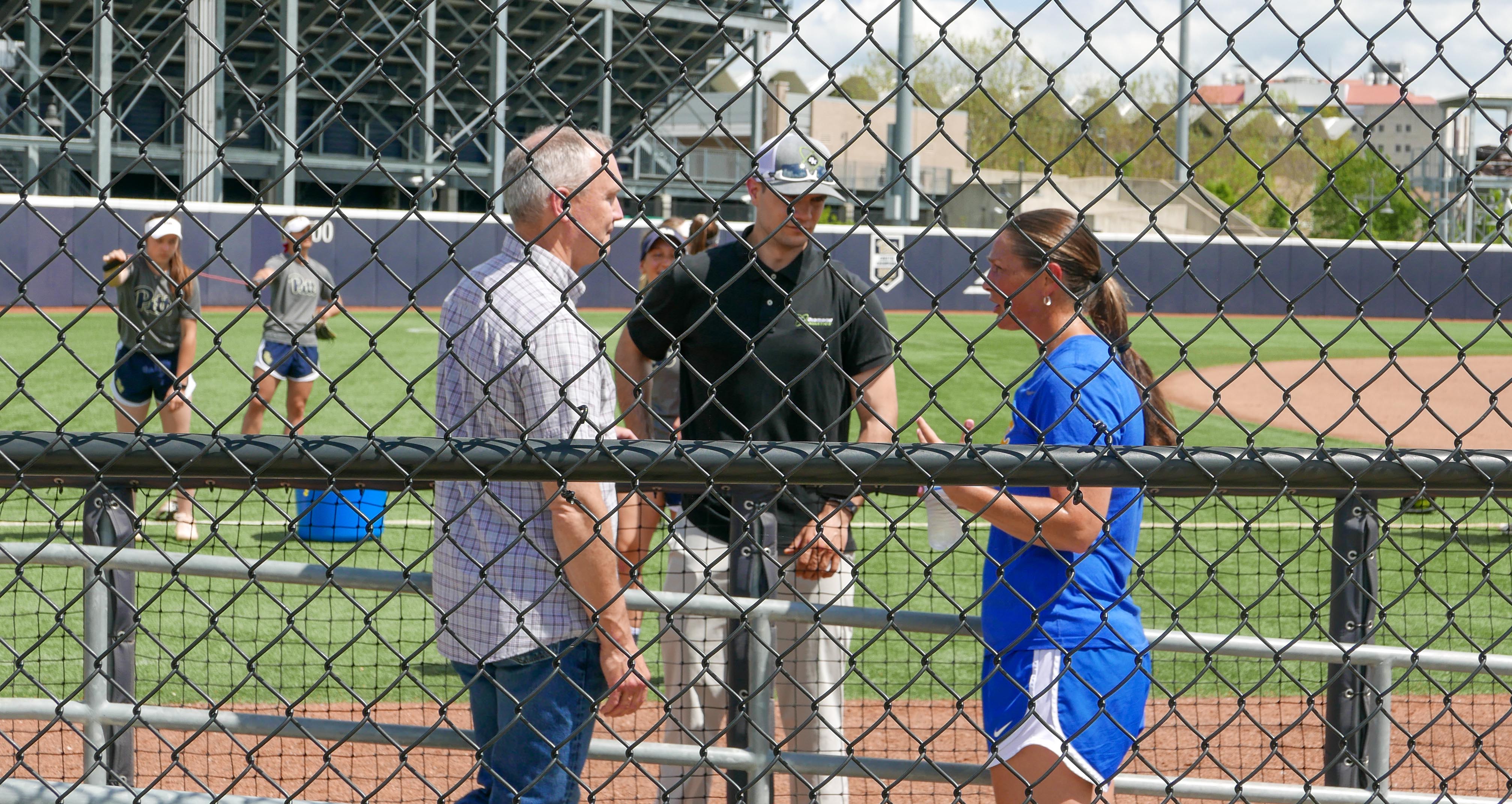 Clarks meeting with softball coach on field