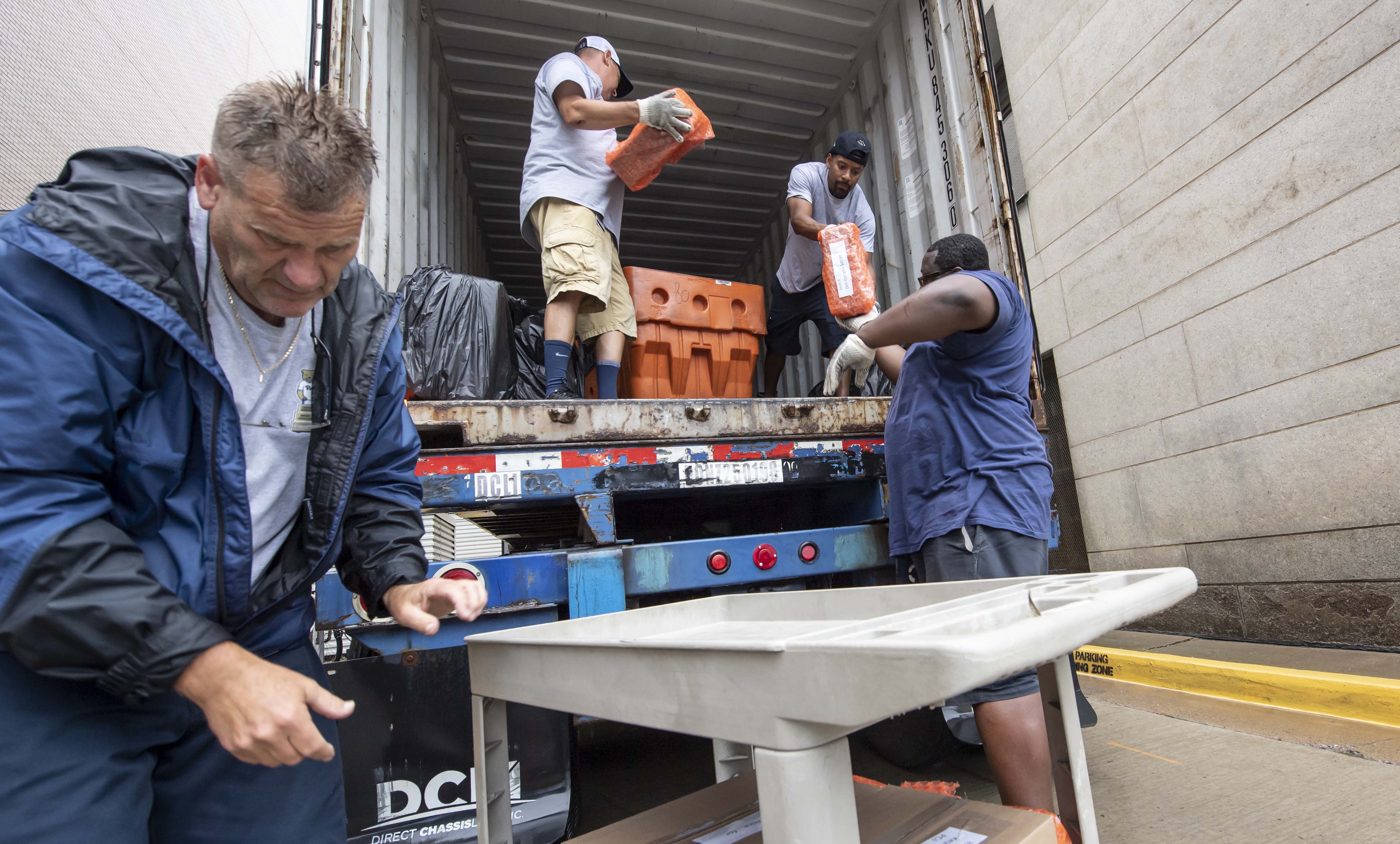 Pitt staff members help Professor Steve Dytman load computers into a truck to send them to the University of Antananarivo in Madagascar. (Aimee Obidzinski) Workers load computers onto a truck