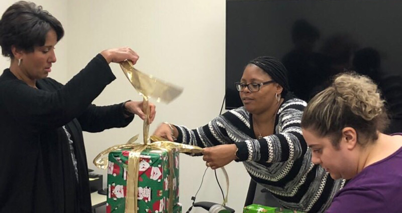 Office of Research employees wrapping presents 
