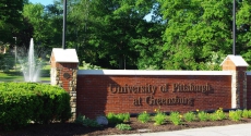 Entrance sign at Pitt–Greensburg with fountain behind it