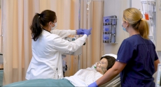 Nursing students work on dummy in bed
