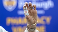 Hand holding vial of vaccine