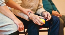 Person holding arm of elderly person