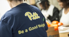 Pitt volunteer with Be a Good Neighbor t-shirt