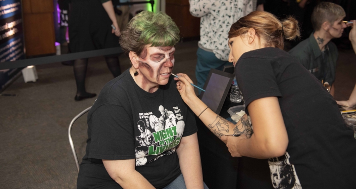 Woman being made up to look like a zombie